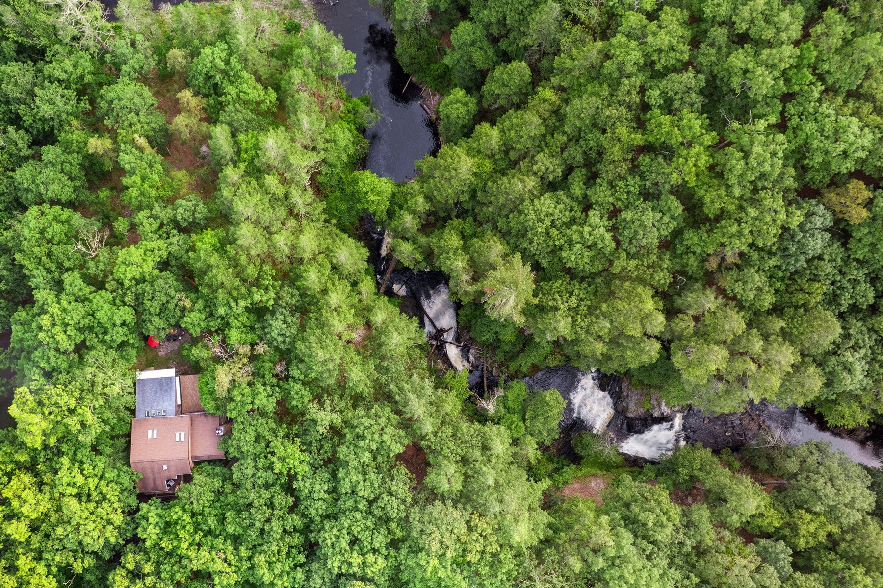 Aerial view of Waterfall Wonder beside forest and a natural waterfall in the Poconos.