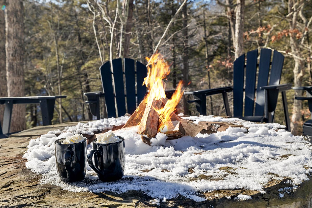 Fire pit seating at Waterfall Wonder with blankets and winter woods around the cabin.