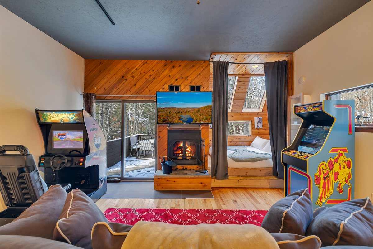 Game room at Waterfall Wonder with arcade-style entertainment, fireplace, and lounge space.