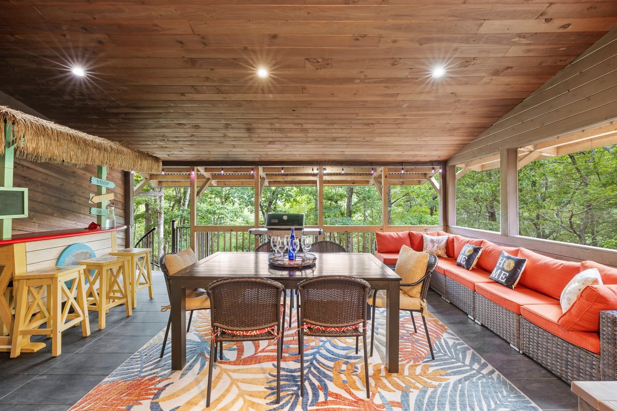 Screened deck dining area at Waterfall Wonder with forest views.